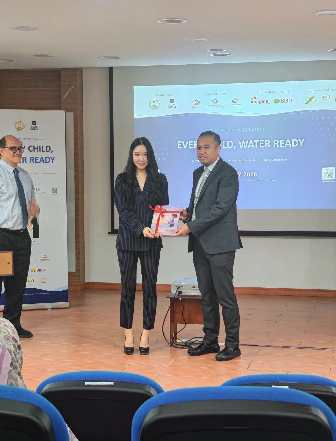 Founder Nari Shin presenting a Marie and the Blue Whale book at the official Blue Whale Water Safety campaign launch in Brunei Darussalam