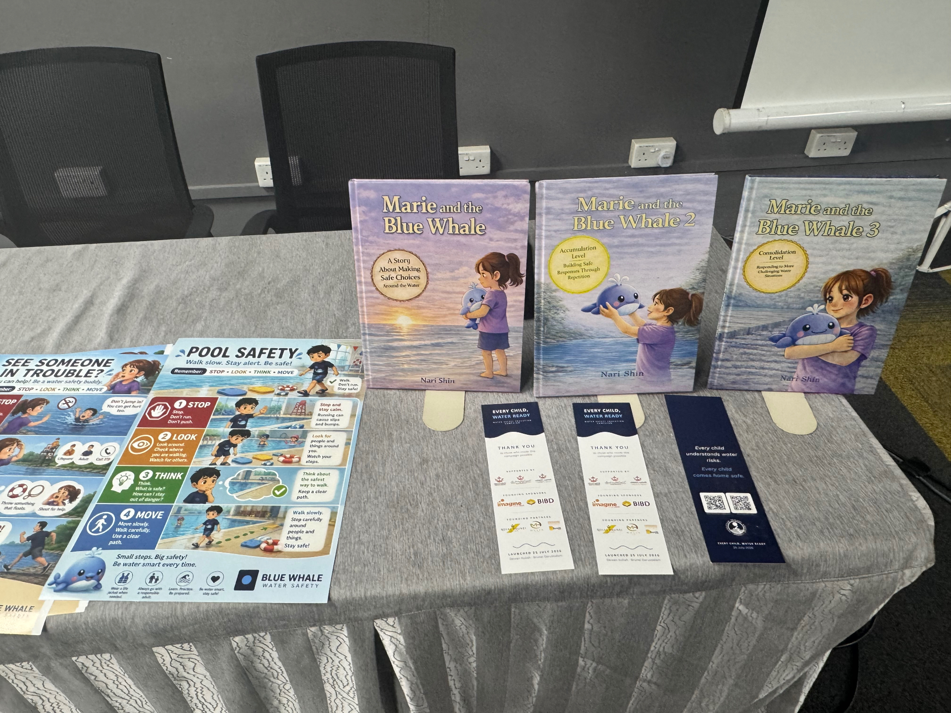 Marie and the Blue Whale books one, two and three displayed with classroom pool safety posters